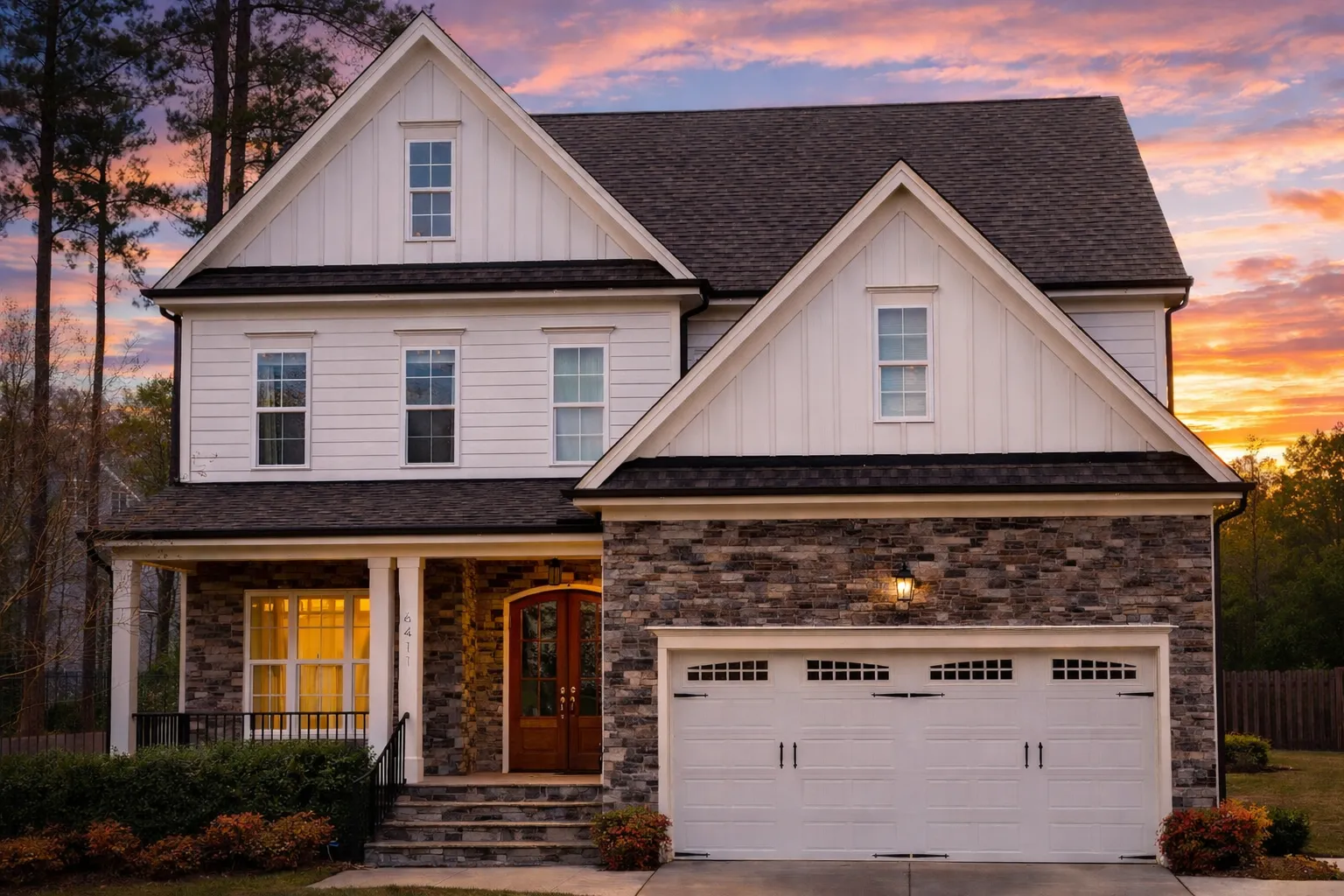 Front elevation of a New American style two-story house with horizontal siding, stone garage accent, black shutters, and symmetrical curb appeal