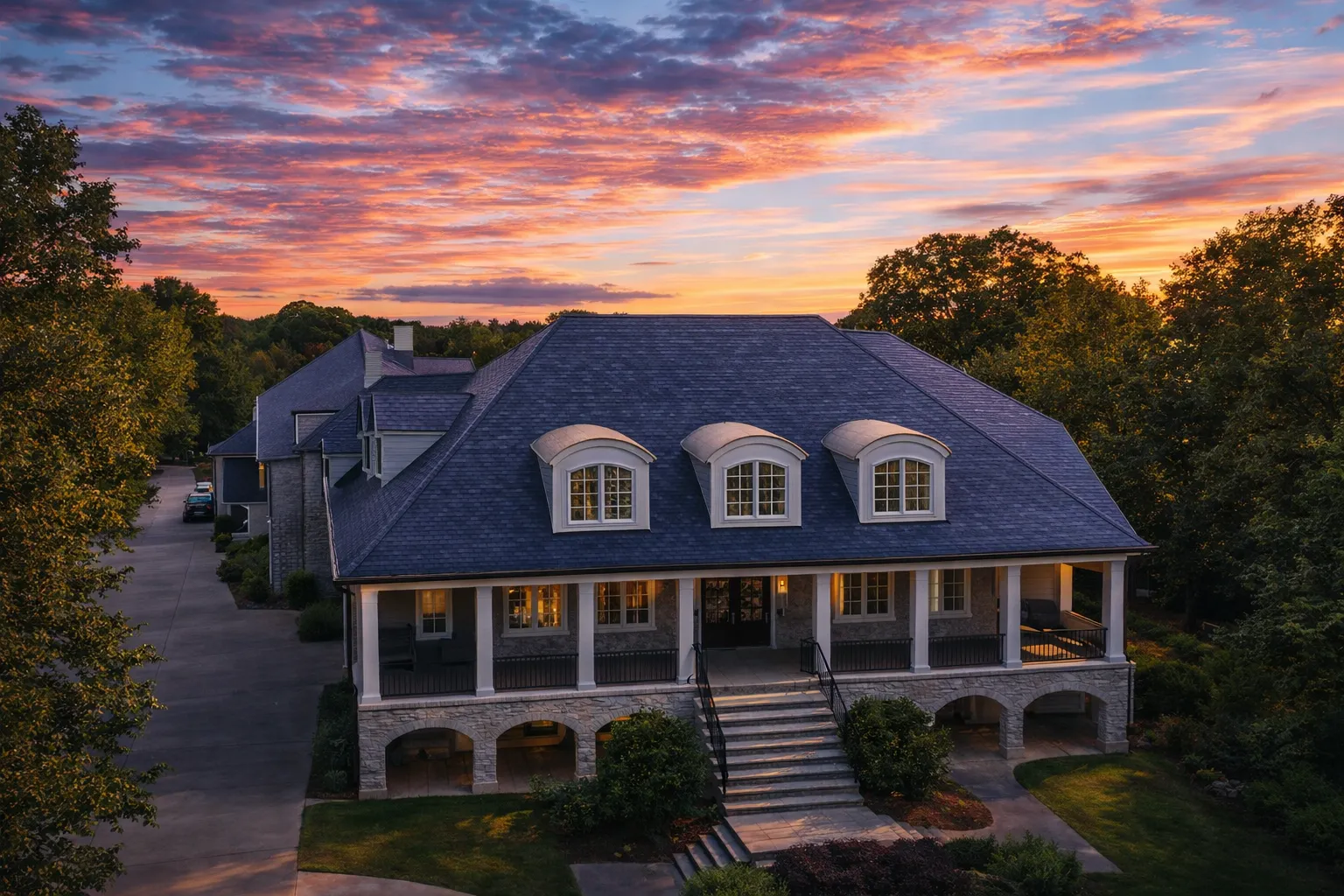 Front elevation of a Georgian Colonial style home with symmetrical brick exterior, double stacked porches, dormer windows, and classical columns