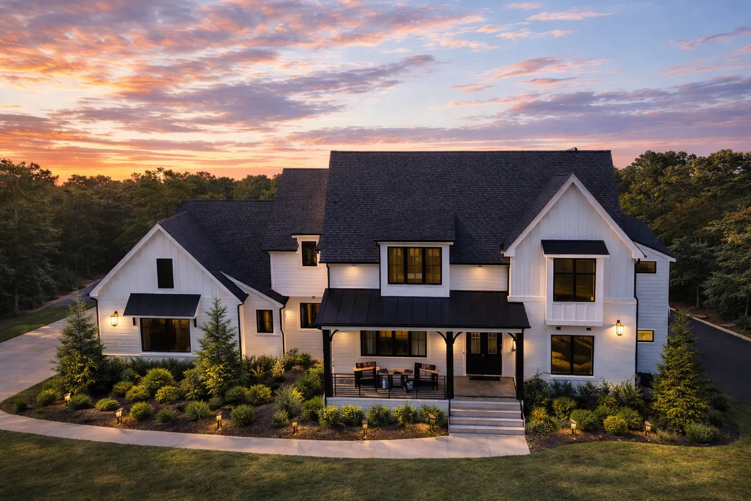 Front elevation of a Modern Farmhouse New American style home with board and batten siding, stone accents, black windows, and classic gabled rooflines