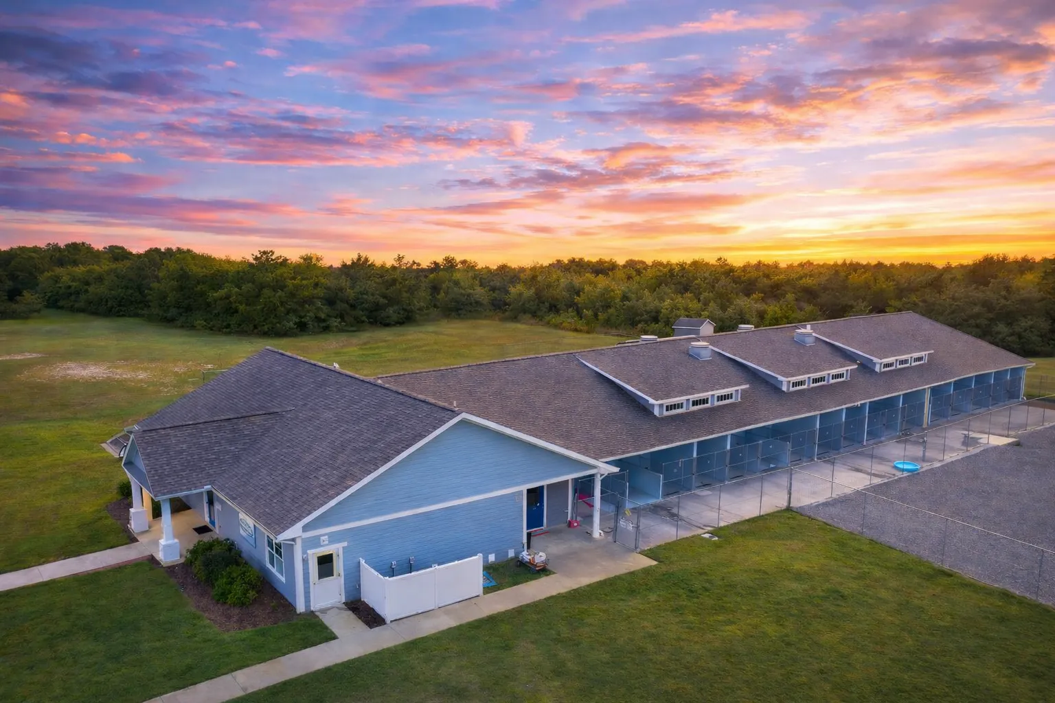 Front elevation of a Traditional Ranch style commercial building with horizontal lap siding, stone wainscoting, dormer windows, and long single-story layout