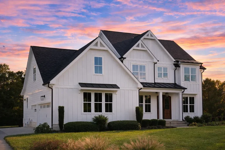 Front elevation of Modern Farmhouse home with white board and batten siding, stone accent wall, black windows, and gabled rooflines