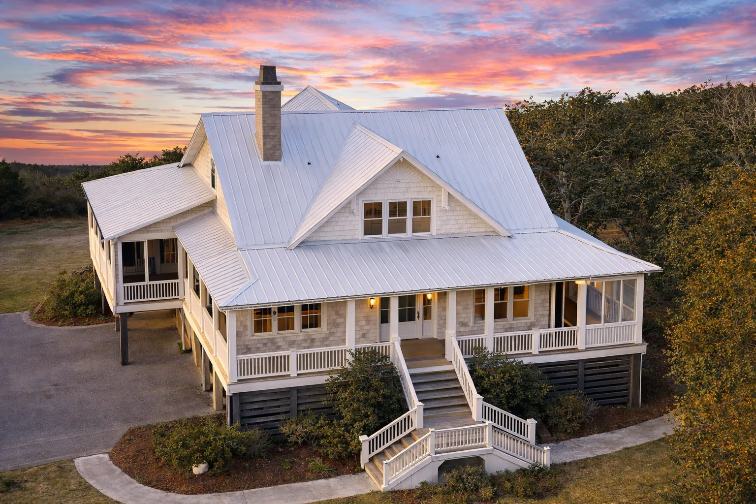 Front elevation of a Cape Cod style home with coastal traditional influences, horizontal siding, shingle gable accents, and a welcoming covered front porch