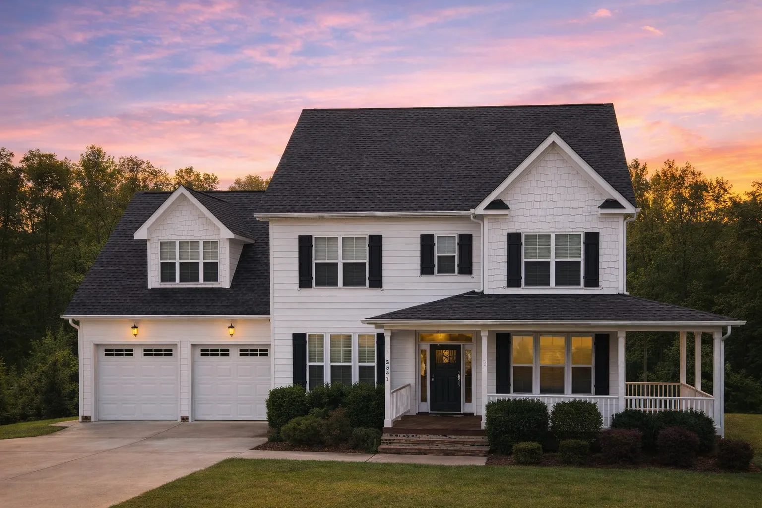 Front elevation of Traditional Colonial style home with lap siding, stone veneer accents, shutters, and covered front porch