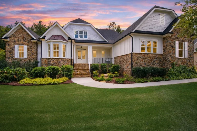 Front elevation of a Traditional Suburban home with brick exterior, horizontal siding, gabled rooflines, and landscaped entry