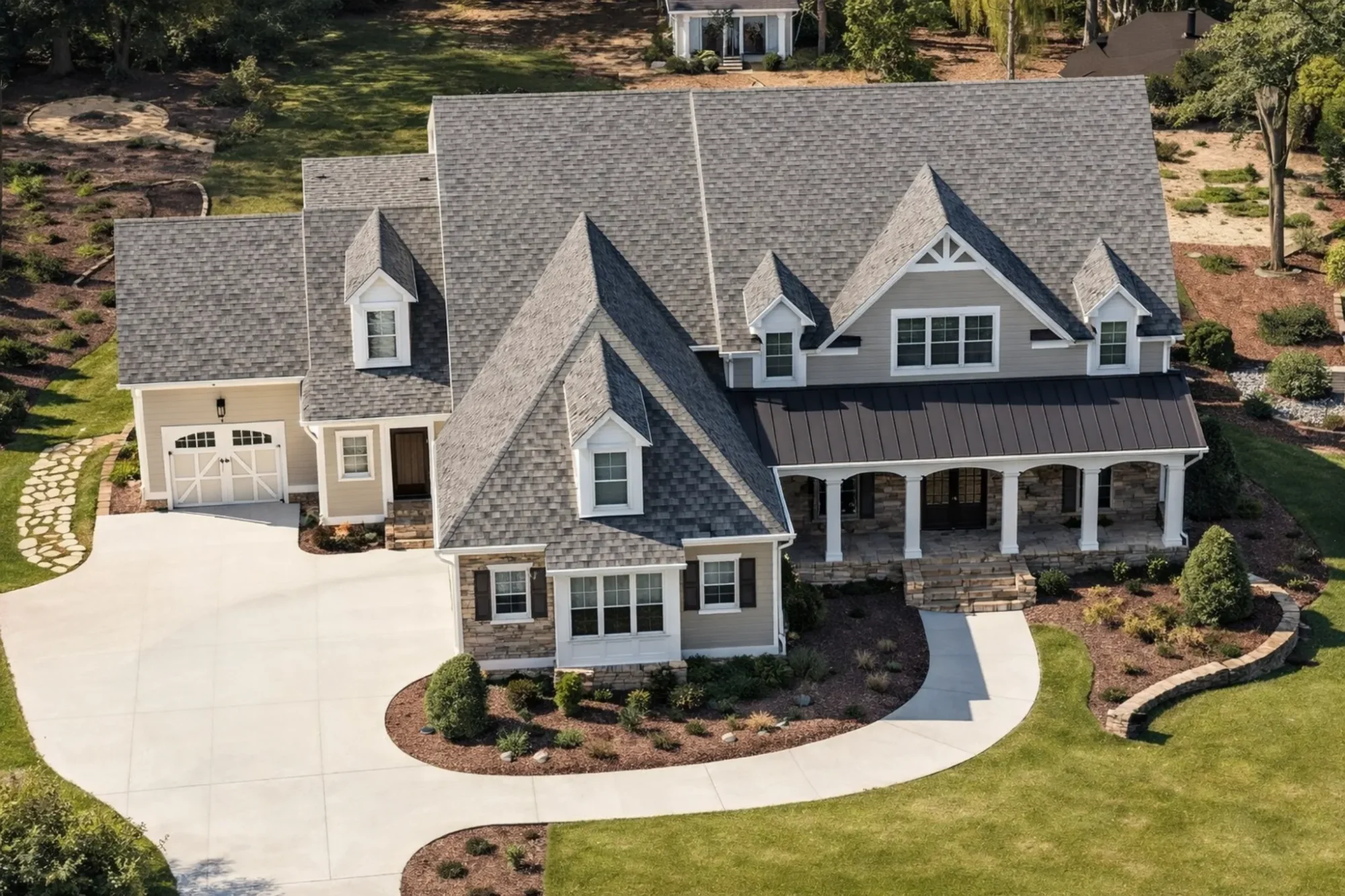 Front elevation of a New American modern traditional two-story home with white horizontal lap siding, stone-accent covered porch, multiple gables, and a centered entry.