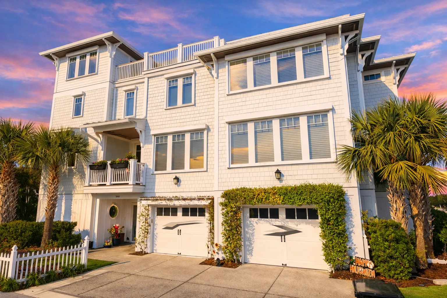 Georgian House Plans 1 Front elevation of a Coastal Shingle Style home featuring white shingle siding, board and batten accents, multiple balconies, and an elevated garage layout