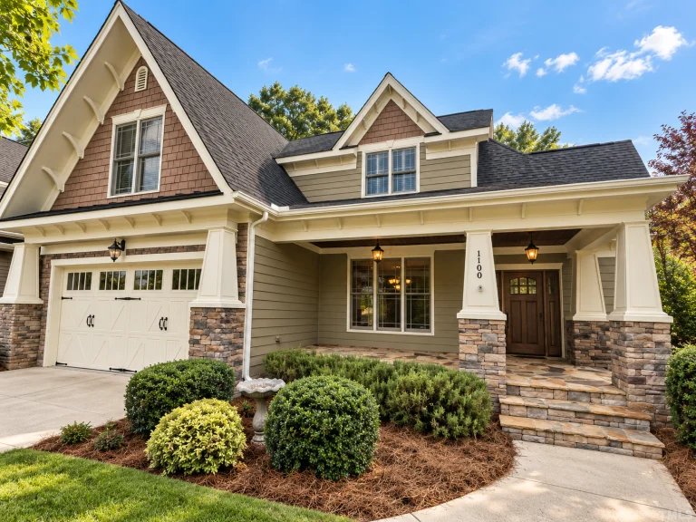 Front elevation of a Craftsman style home featuring horizontal siding, shingle accents, stone porch columns, and a welcoming covered front porch