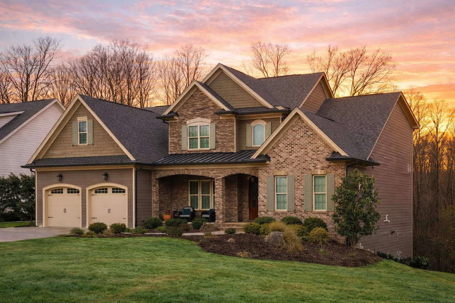 Front elevation of a New American Traditional two-story home with stone veneer, brick facade, lap siding, and shake gable accents