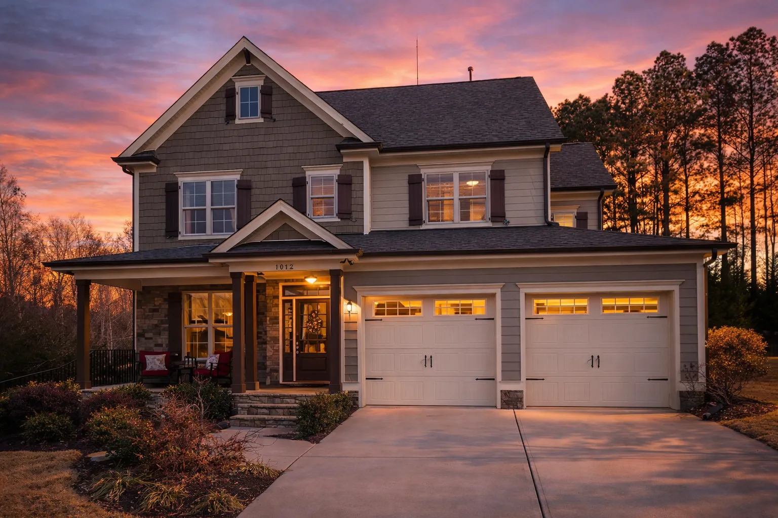 Front elevation of a New American modern traditional house with horizontal siding, stone accents, black shutters, and a three-car garage