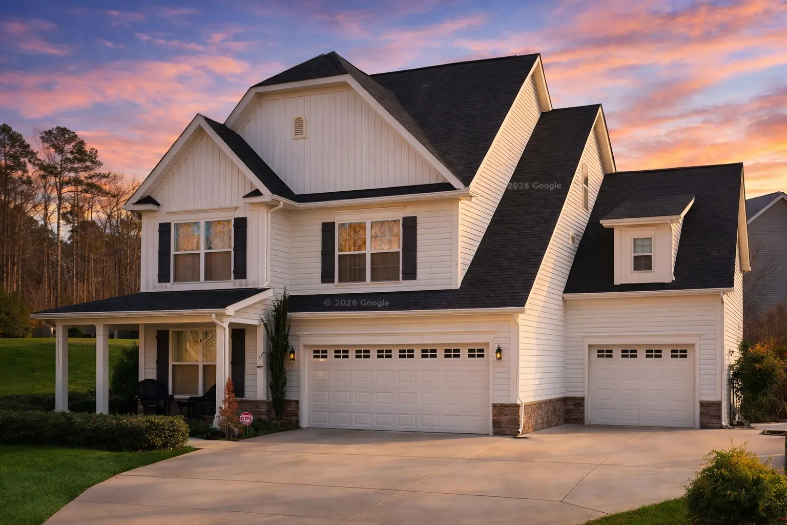 Front elevation of New American style home with traditional colonial influence, featuring horizontal siding, board and batten gables, and a three-car garage