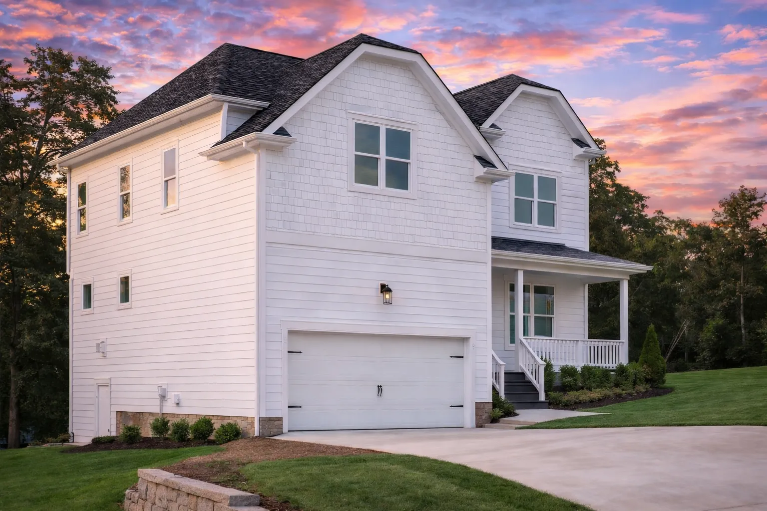Front elevation of a Modern Farmhouse style home with white horizontal siding, gable rooflines, covered porch, and attached 2-car garage