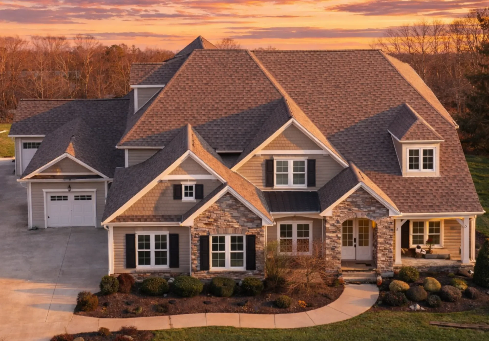 Front elevation of a New American Modern Traditional house featuring stone veneer, horizontal siding, gabled rooflines, and classic shutters