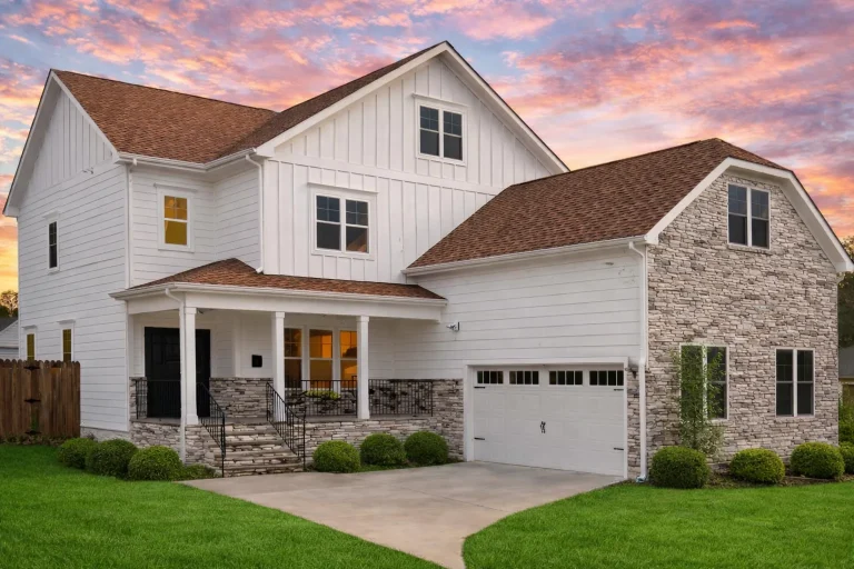 Front elevation of a Traditional Colonial style home with brick façade, white lap siding, black shutters, gable roof, and red front door