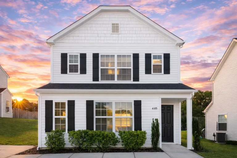 Front elevation of a Colonial style two-story house featuring horizontal lap siding, black shutters, and a traditional covered entry porch with columns.