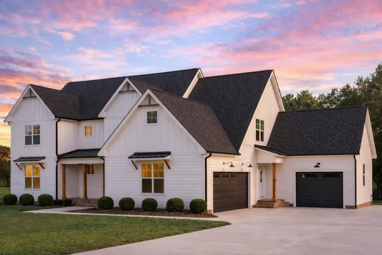 Front elevation of Modern Farmhouse style home with horizontal lap siding, Tudor-inspired gable trim, covered porch, and attached garage