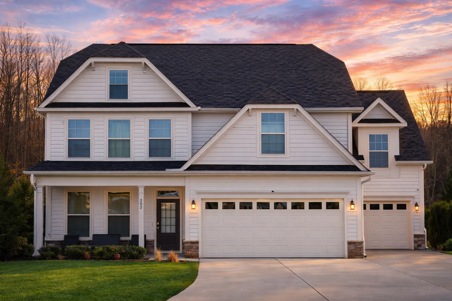 Front elevation of a New American Modern Traditional house featuring horizontal siding, stone accents, and a three-car garage