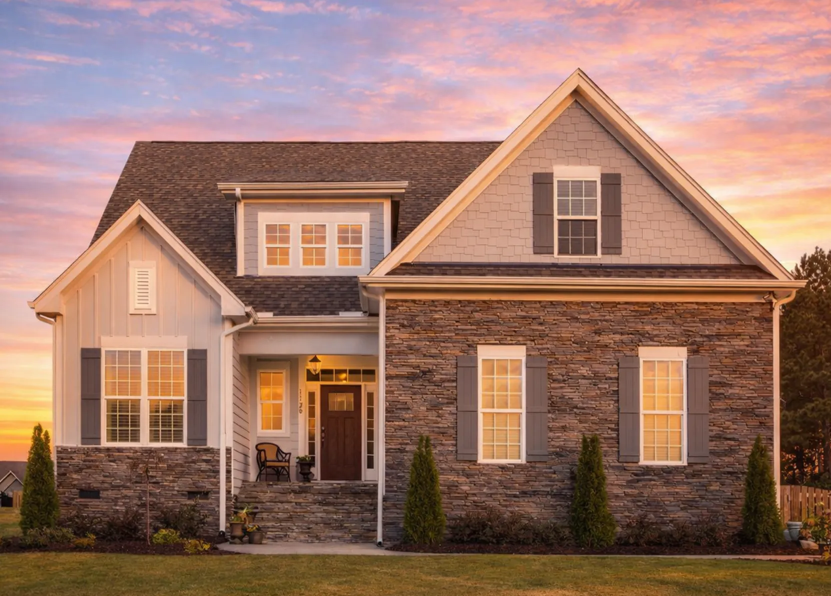 Front elevation of a modern farmhouse style home featuring board and batten siding, gabled rooflines, black front door, and two car garage