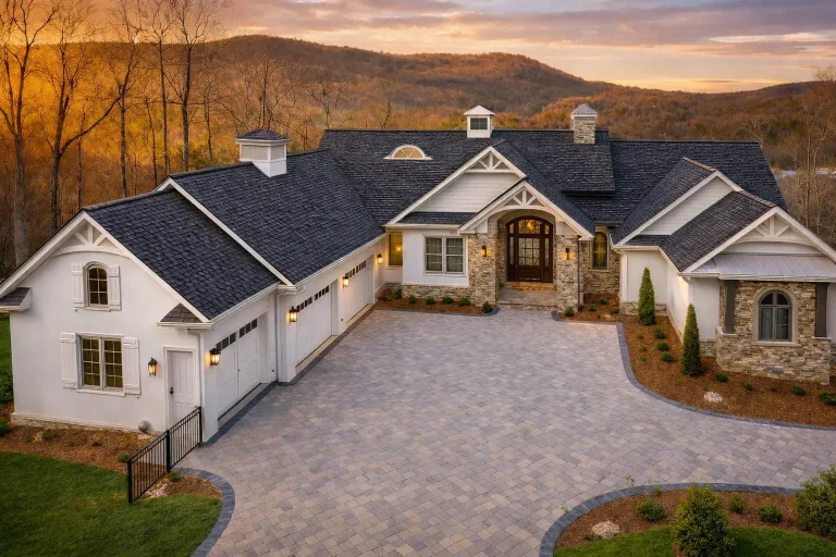 Front exterior of a New American modern traditional house with board and batten siding, stone accents, and side-entry garage