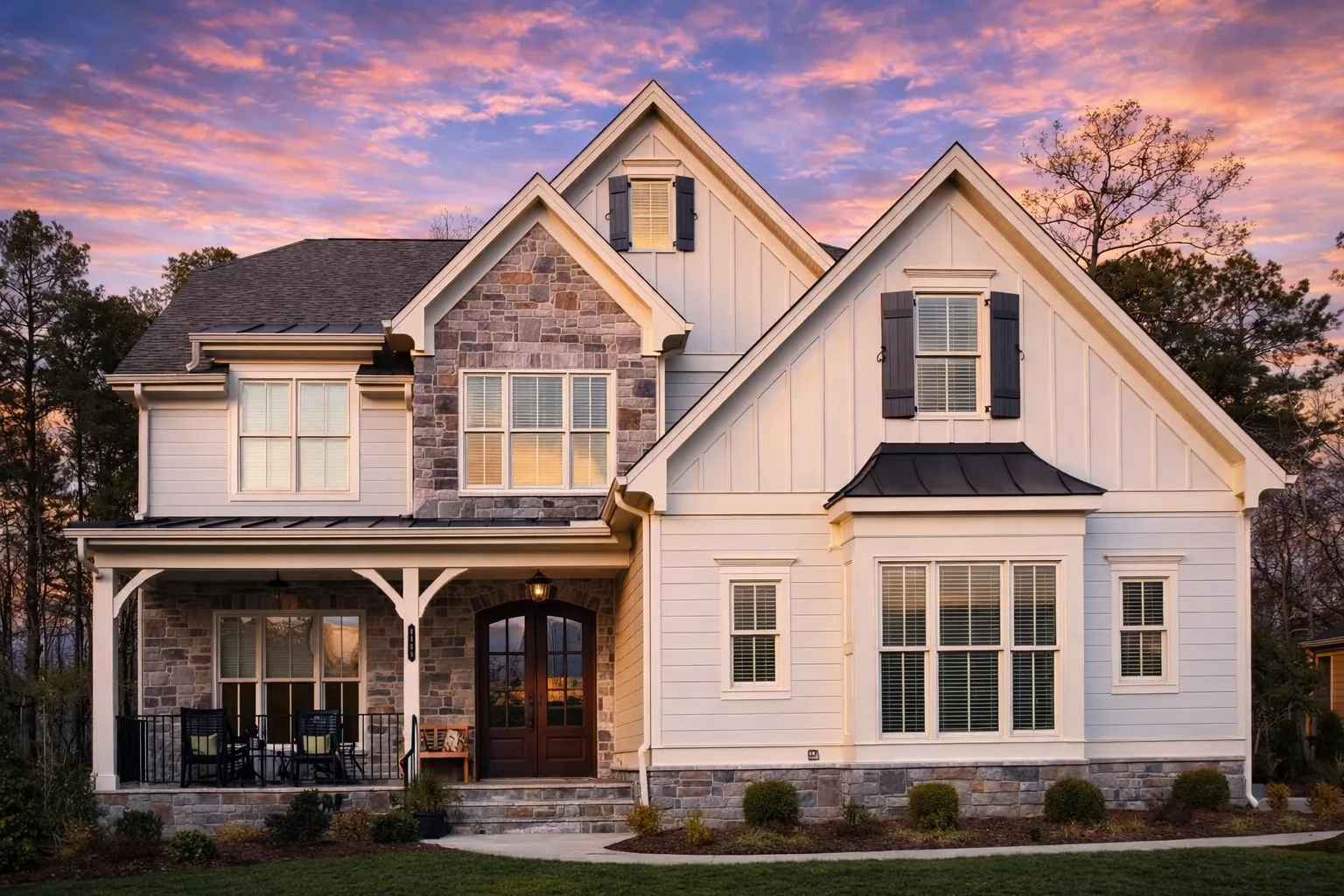 Front elevation of a New American Modern Farmhouse with board and batten siding, stone accents, symmetrical windows, and a covered front porch