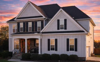 Front elevation of a Traditional Colonial New American style house featuring horizontal lap siding, board-and-batten gables, symmetrical windows, and a covered front porch