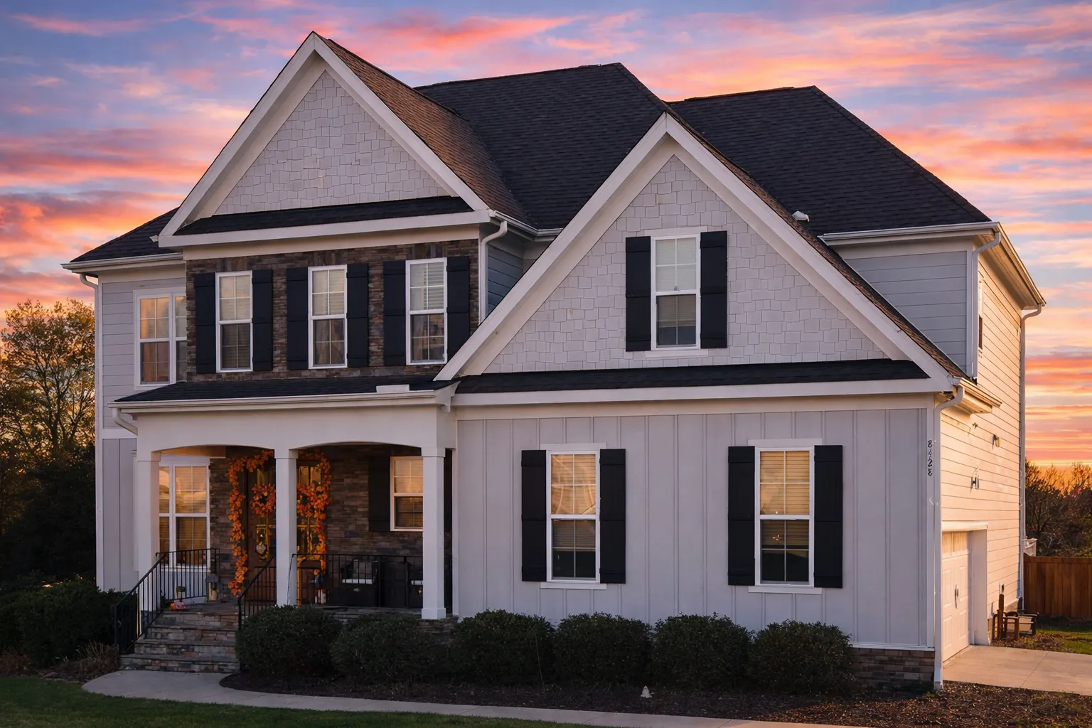 Front elevation of a Traditional Colonial New American style house featuring horizontal lap siding, board-and-batten gables, symmetrical windows, and a covered front porch