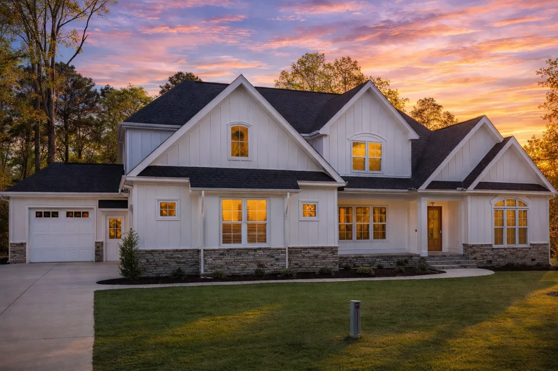 Front elevation of a New American Craftsman style house featuring board and batten siding, stone accents, gabled rooflines, and a welcoming covered entry