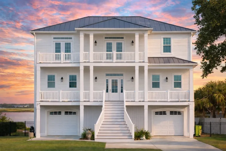 Front elevation of a Charleston Low Country style raised home featuring double stacked porches, lap siding, masonry base, and classic Southern symmetry