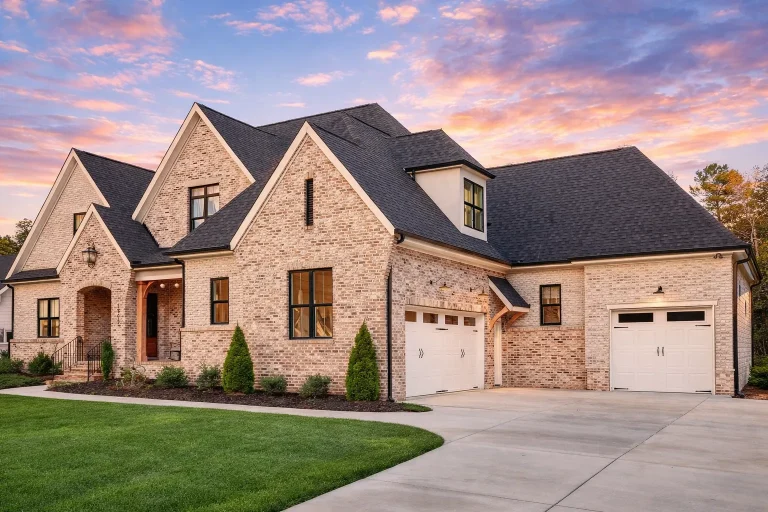 Front exterior view of a New American style home featuring brick construction, board and batten siding, gabled rooflines, and a covered entry porch