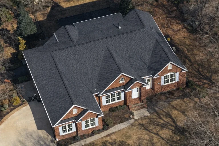 Front elevation of a Traditional Ranch style home with full brick exterior, symmetrical gabled roofline, classic shutters, and a covered entry