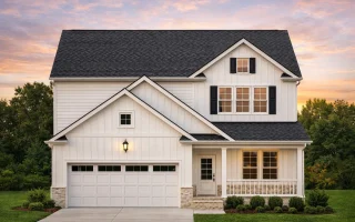 Front view of a Traditional Craftsman style home featuring gray lap and shingle siding, brick base columns, and a welcoming front porch with white trim details.