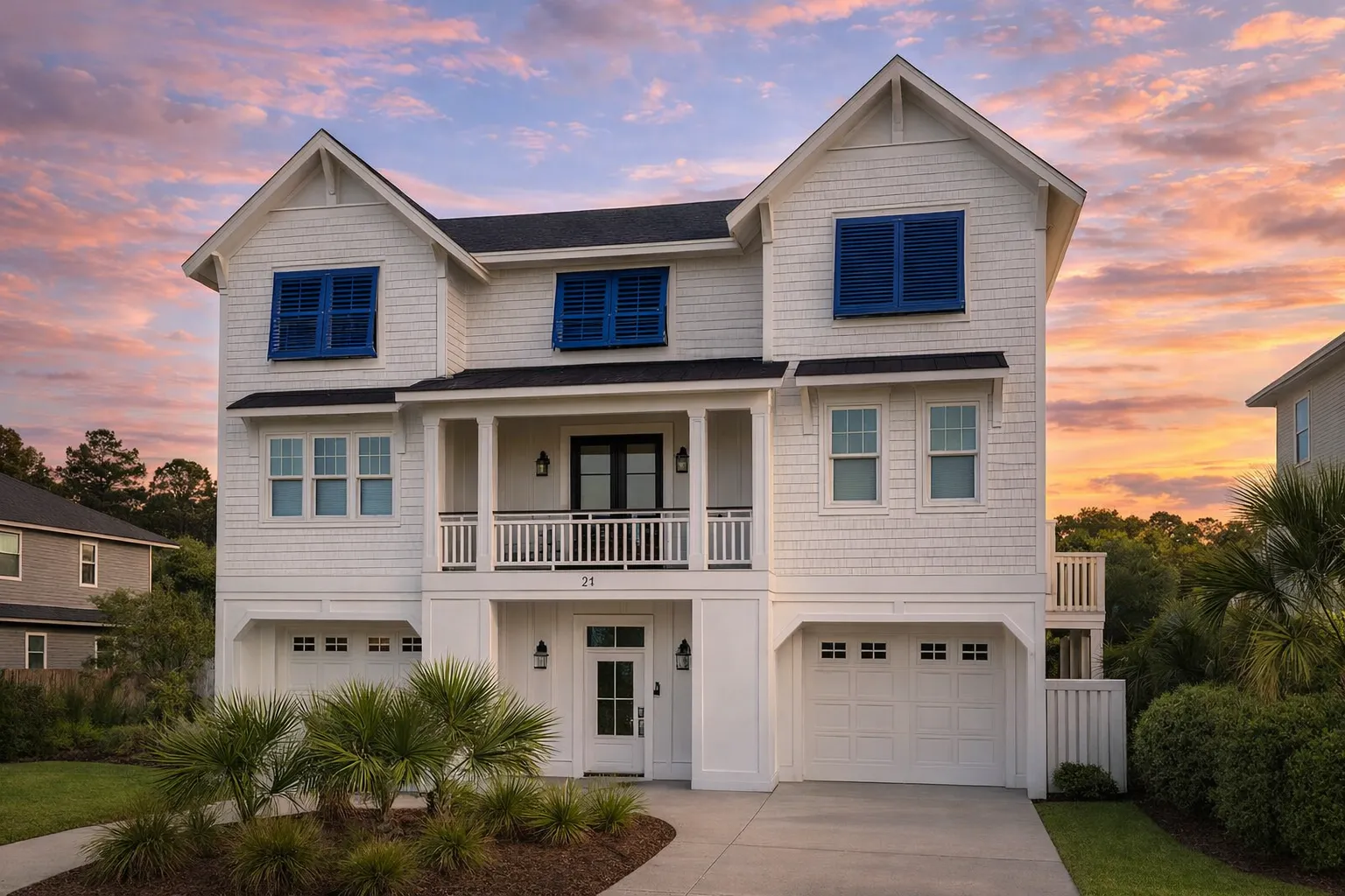 Front elevation of a coastal shingle style house featuring raised foundation, covered porches, blue shutters, and classic beach architecture