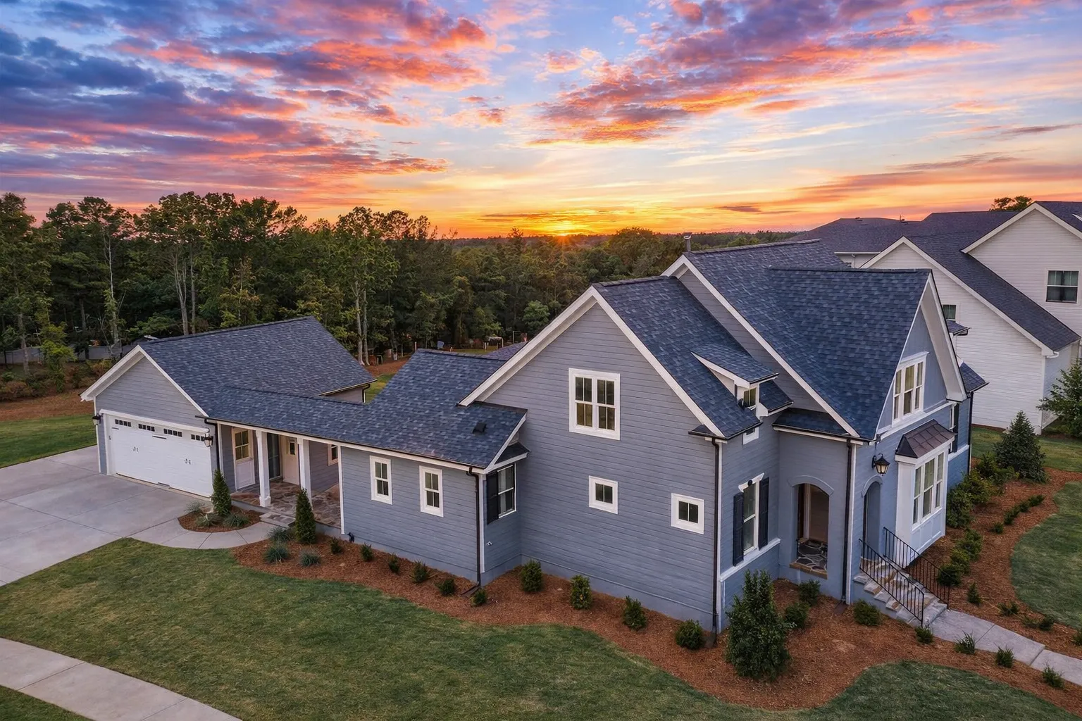 Front view of Modern Farmhouse style home featuring brick and board and batten exterior, gabled roofline, and symmetrical windows