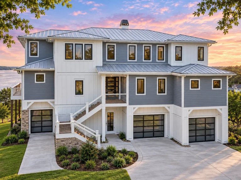 Modern Suburban House Plans 2 Front exterior view of a luxury coastal style home with elevated foundation, horizontal siding, multiple garages, and expansive balconies overlooking the water
