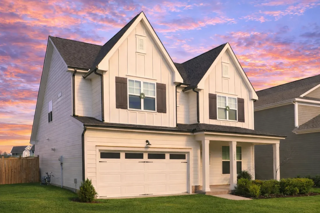 Front elevation of a New American Traditional home with coastal Cape Cod influence, featuring shingle accents, lap siding, and a welcoming covered porch