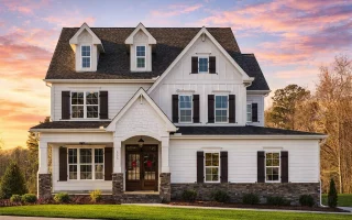 Front elevation of a New American Traditional style home featuring board and batten siding, horizontal lap siding, stone foundation, and classic shutters