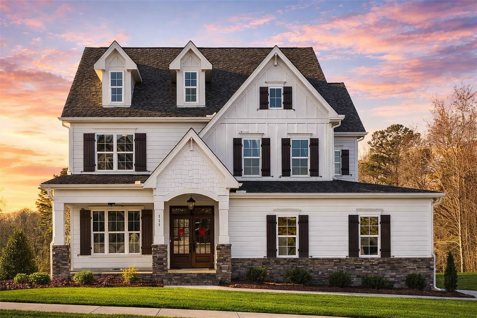 Front elevation of a New American Traditional style home featuring board and batten siding, horizontal lap siding, stone foundation, and classic shutters