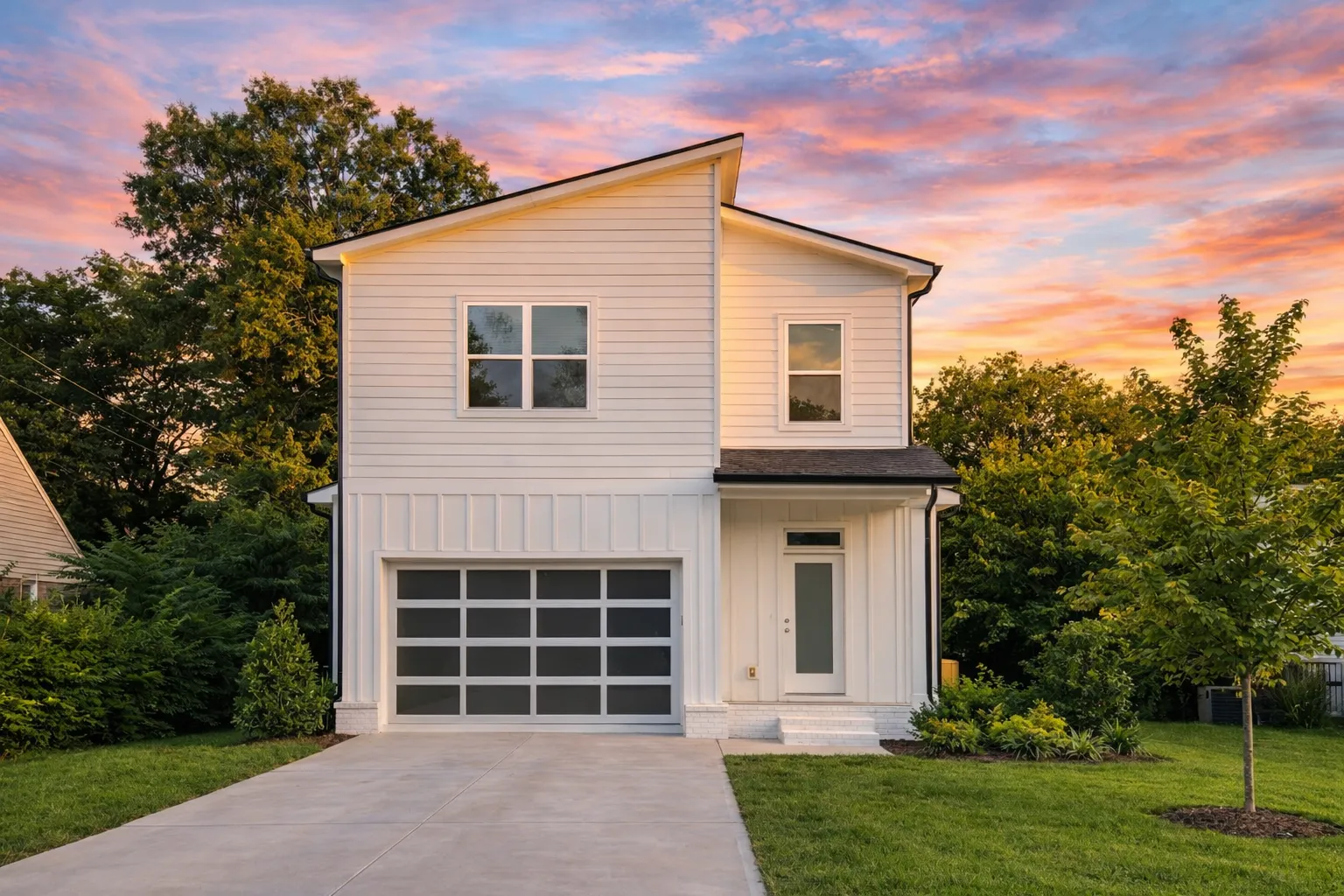 Front view of a Modern Farmhouse style two-story home featuring board and batten with horizontal siding, brick base accents, and a single-car garage