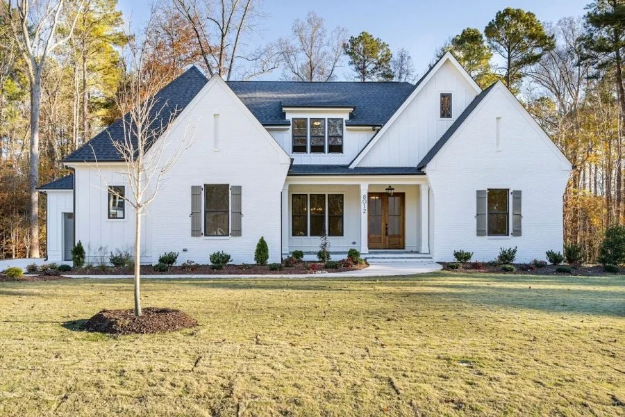House Plans with Spacious Laundry Room 5 Front elevation of a Modern Farmhouse style home with white painted brick, board and batten siding, steep gables, and covered porch