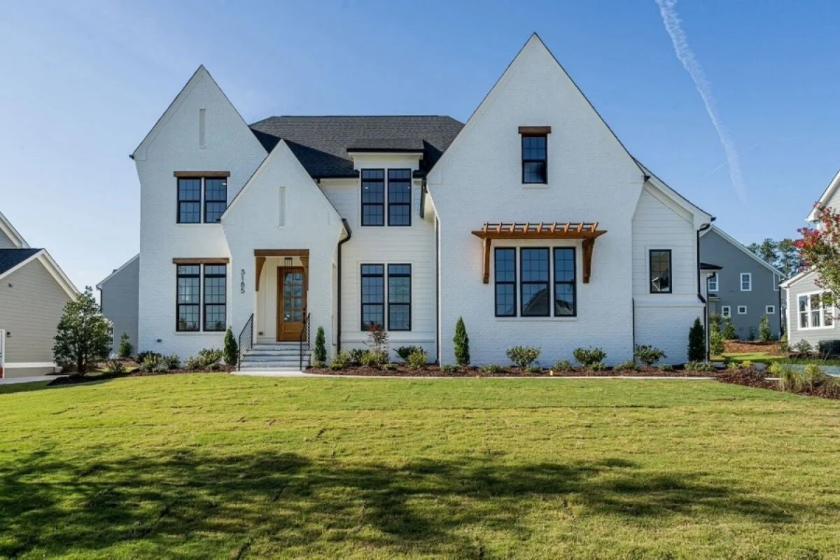 House Plans with Elevator 21 Front elevation of a Modern Farmhouse style home featuring white stucco exterior, board and batten accents, steep gabled rooflines, and black-framed windows