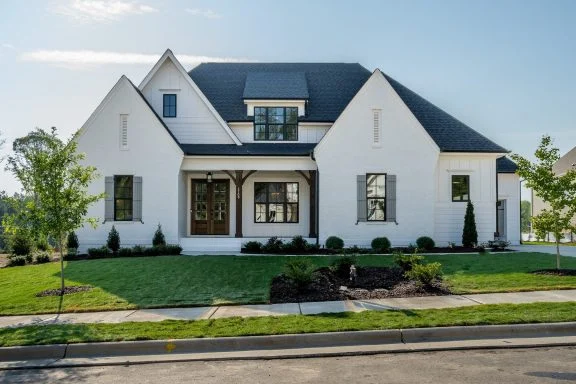 Adobe House Plans 29 Front elevation of a modern farmhouse style home featuring white painted brick, board and batten siding, steep gabled rooflines, and symmetrical architecture