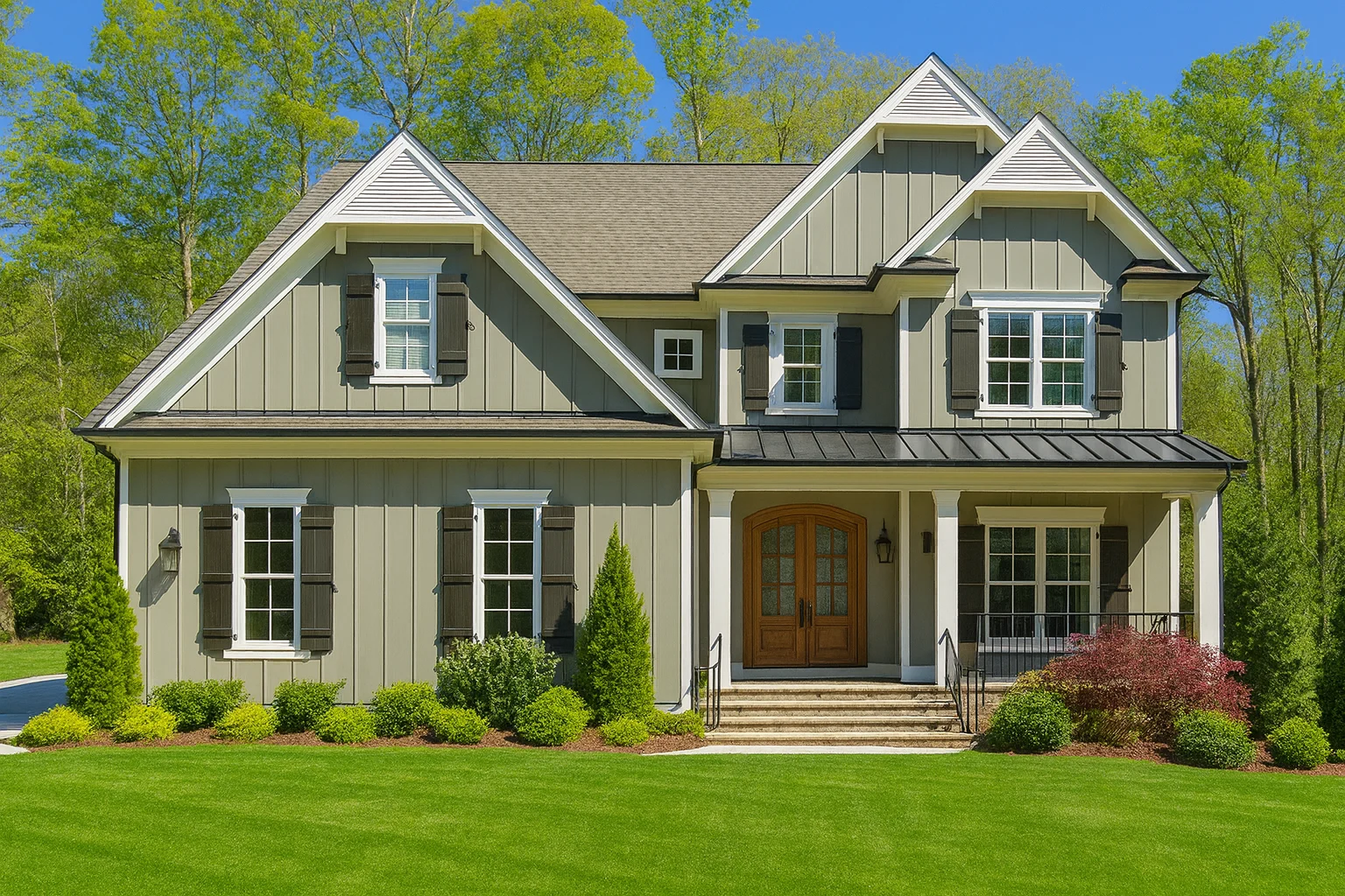 Front exterior of a New American Traditional Colonial house with lap siding, board-and-batten accents, symmetrical windows, and covered entry porch