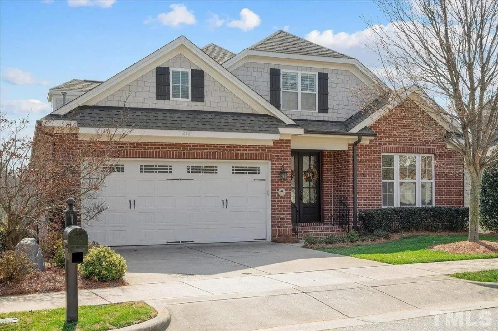 Traditional brick-and-shake home with front-entry 2-car garage, gabled dormers, and covered entry—Craftsman/Cottage accents