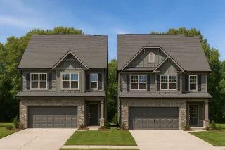 Front elevation of a Traditional New American style two-story home featuring gray siding, board and batten accents, stone veneer base, and dark shutters for balanced curb appeal.