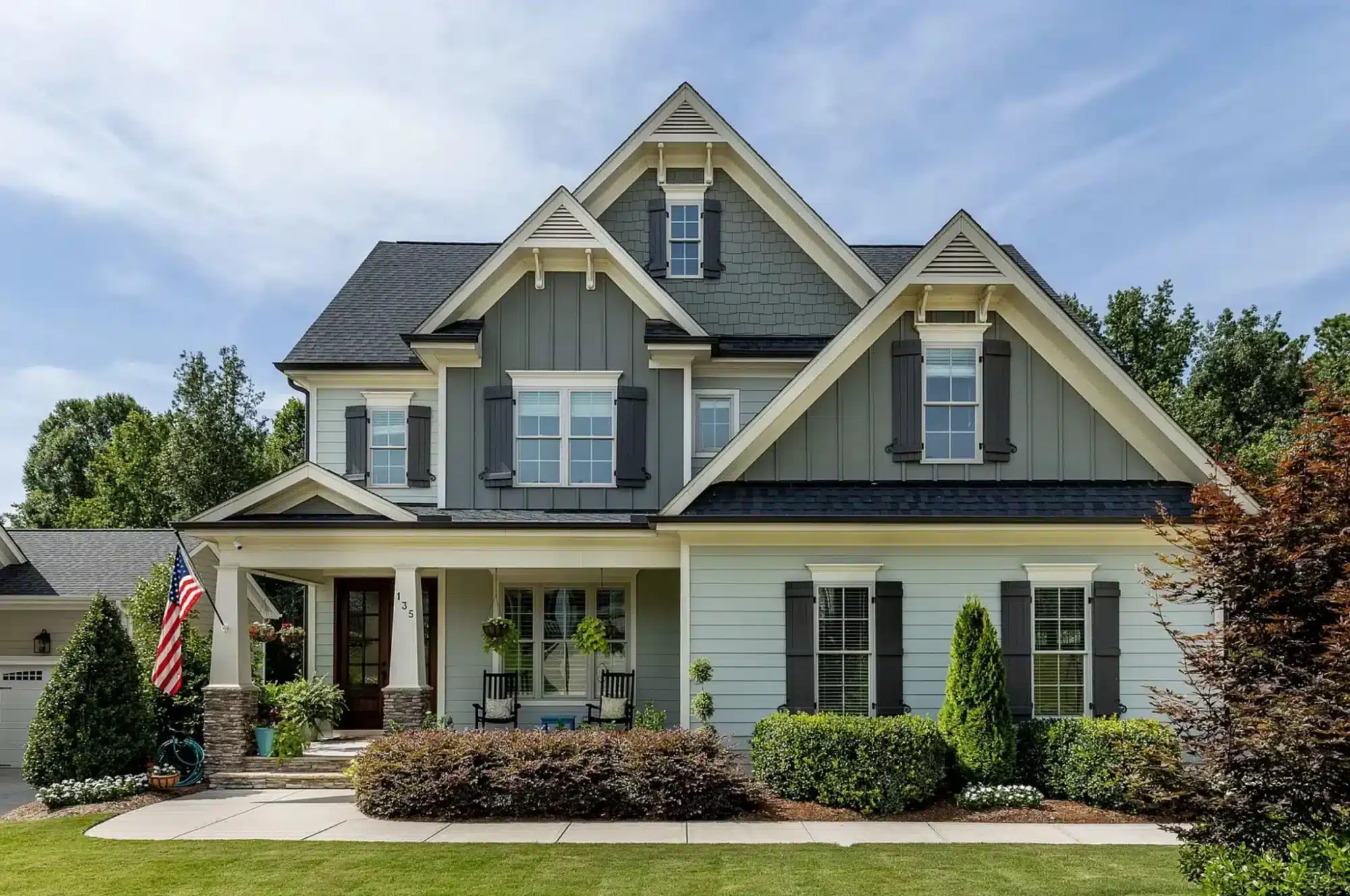 Two-story Craftsman Farmhouse with stone porch columns, gable brackets, and board and batten siding