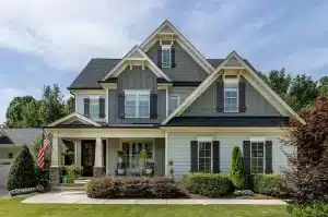 Two-story Craftsman Farmhouse with stone porch columns, gable brackets, and board and batten siding