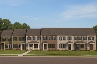 Front elevation of a Traditional Colonial style townhome featuring horizontal siding, classic symmetry, and clean multi-unit architectural detailing