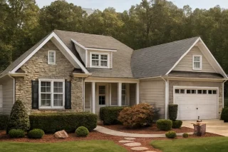 Front view of a Traditional Colonial style home featuring stone and siding exterior, gabled rooflines, and a welcoming front porch entry